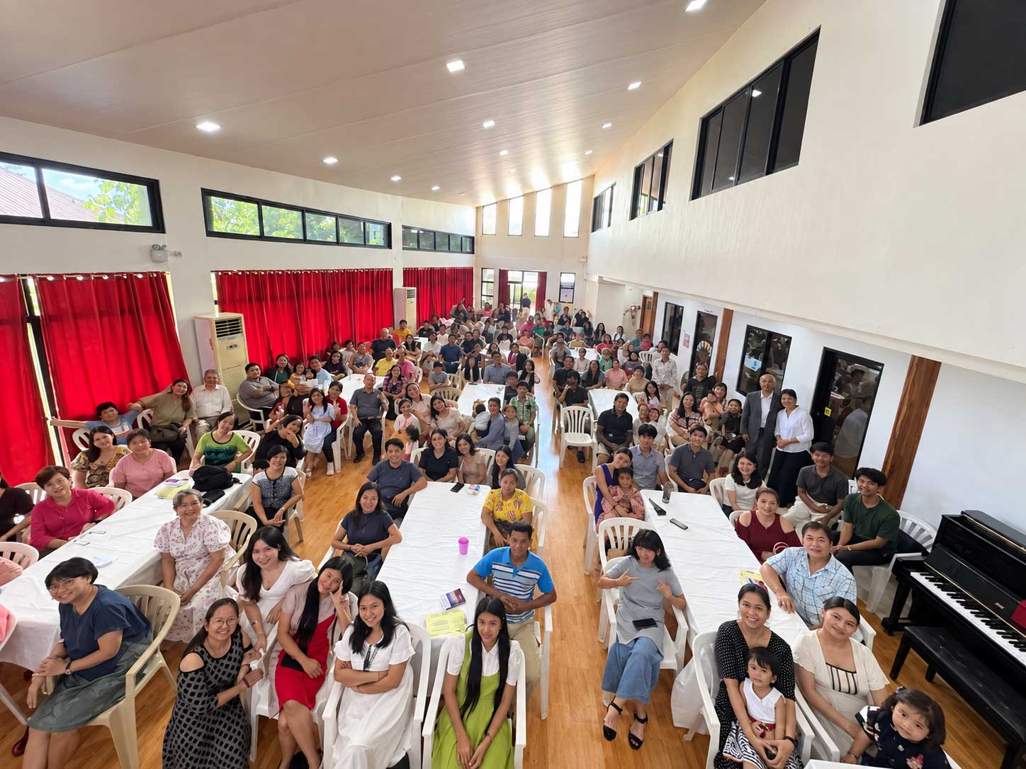 A congregation seated together with Bibles and notebooks open during a Sunday service